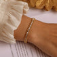 Video courte montrant le bracelet tennis avec chaîne à maillons à bille en acier inoxydable plaqué or, ce bracelet rivière présenté sur un poignet de femme est orné de toute sa longueur de zircones cubiques blanches