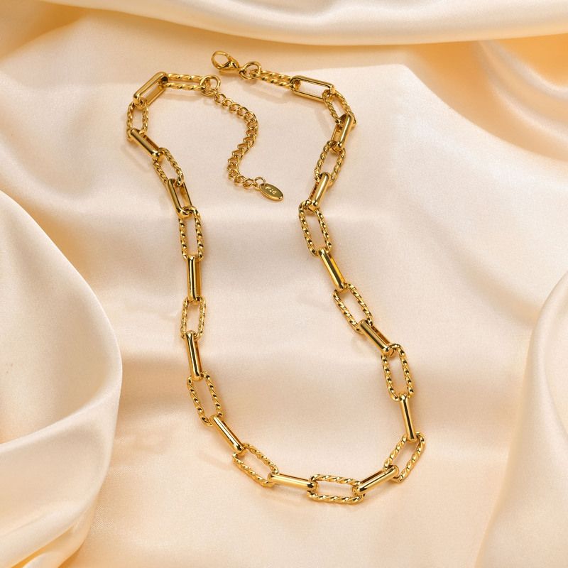 Vidéo courte avec jolie femme brune vêtu d'un chemisier blanc arborant un magnifique collier avec chaîne d'ancre avec maillons trombones en acier inoxydable plaqué or